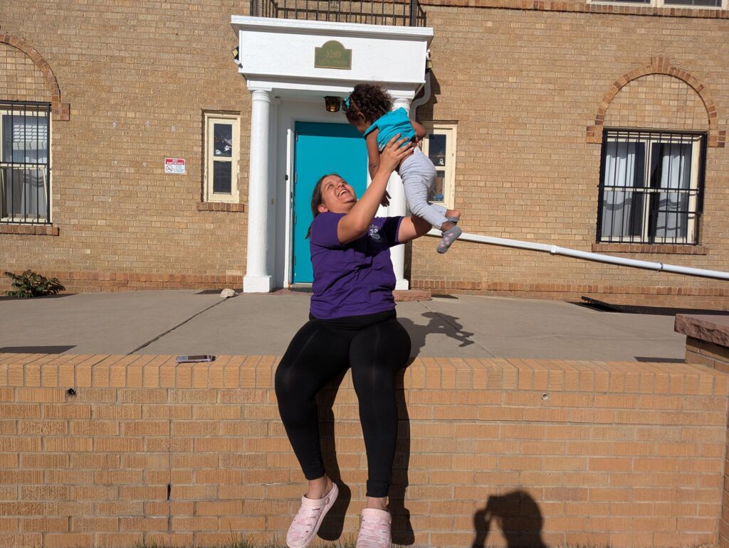 Yaney and her daughter, Rosianny, in front of Warren Village at First Step