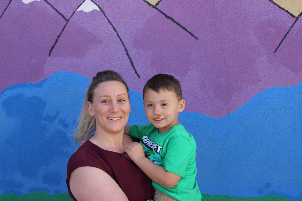 Jessica holding her son, Deven, smiling.